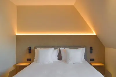 a bedroom with a bed with white pillows at Hotel De Zalm in Herentals