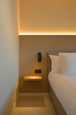 a bedroom with a bed with a night stand next to it at Hotel De Zalm in Herentals