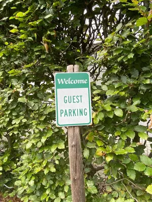 a sign that says guest parking on a wooden pole at de graslelie in Schoten