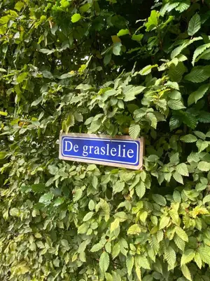a blue sign that says de graciaete in a bush at de graslelie in Schoten
