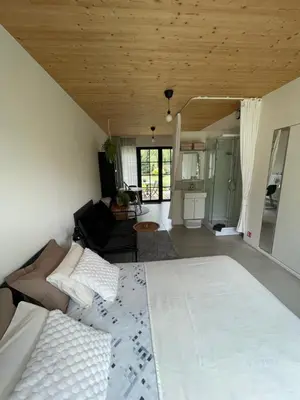a bedroom with a bed and a living room at de graslelie in Schoten