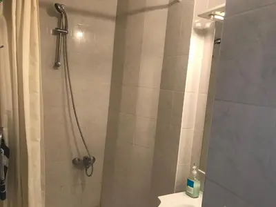 a bathroom with a shower with a toilet and a sink at Appartements Brussel in Brussels