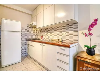 a kitchen with white cabinets and a white refrigerator at Appartements Brussel in Brussels
