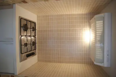 a tiled shower with a stove in a bathroom at Appartements Brussel in Brussels