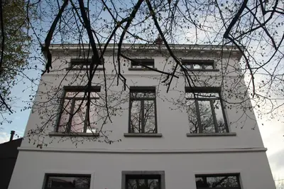 a white building with windows on the side of it at B&B Le Verger in Brussels