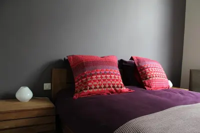 a bed with red and white pillows on it at B&B Le Verger in Brussels