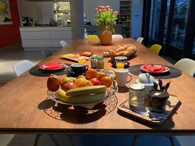 a table with a bowl of fruit and bread on it at B&B Le Verger in Brussels