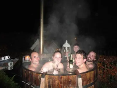 a group of men in a hot tub at night at B&B Maarle in Poppel