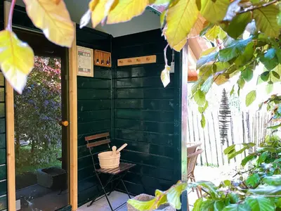 a green house with a bench in front of it at B&B Maarle in Poppel