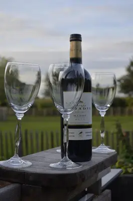 a bottle of wine and two empty wine glasses at B&B Maarle in Poppel