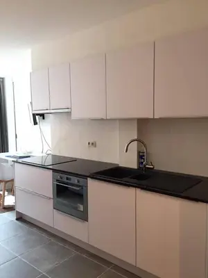 a kitchen with white cabinets and a sink and a stove at Studio Liepoo in Ghent