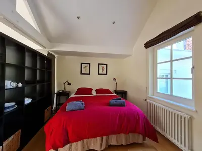 a bedroom with a large red bed with red pillows at Maison Montana in Brussels