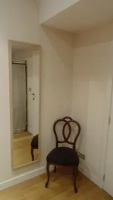 a chair sitting in a room with a mirror at Maison Montana in Brussels