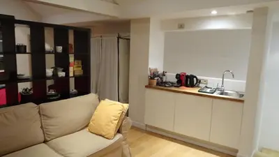 a living room with a couch and a kitchen at Maison Montana in Brussels