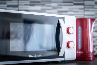 a microwave sitting on a table next to a red mug at Luxury Studio In the EU Area in Brussels