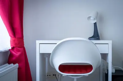 a white chair sitting next to a desk with a lamp at Luxury Studio In the EU Area in Brussels