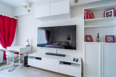 a white bedroom with a bed and a tv on a wall at Luxury Studio In the EU Area in Brussels