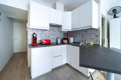 a kitchen with white cabinets and a black counter top at Luxury Studio In the EU Area in Brussels
