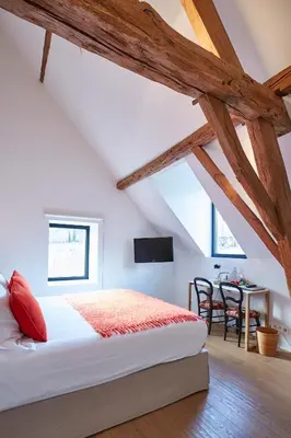 a bedroom with a bed and a desk in a attic at B&B Park7 in Huldenberg