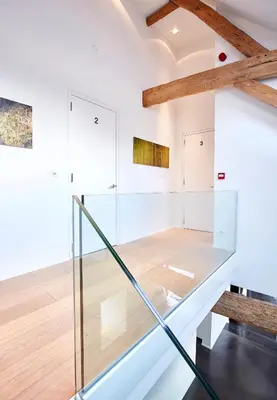 a glass staircase in a room with a wooden floor at B&B Park7 in Huldenberg