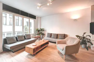 a living room with a couch and a table at Light House Lodge. Apartment in Center of Antwerp in Antwerp