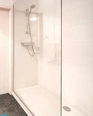 a shower with a glass door in a bathroom at Light House Lodge. Apartment in Center of Antwerp in Antwerp