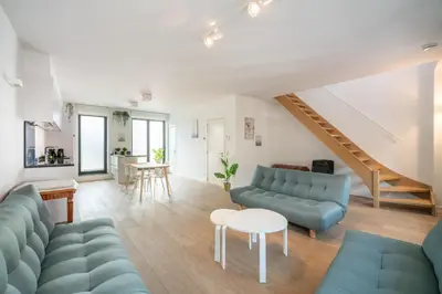 a living room with blue couches and a table at Light House Lodge. Apartment in Center of Antwerp in Antwerp