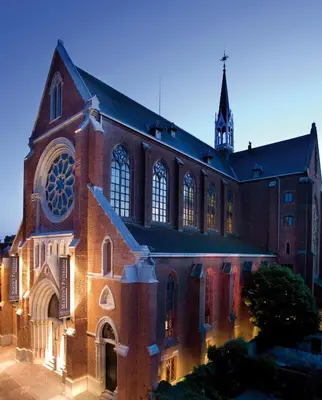 a large brick church with a clock tower in the background at Martin's Patershof in Mechelen