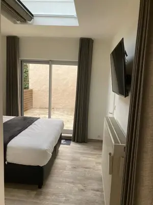 a bedroom with a bed and a tv and a window at RS10 B&B Turnhout in Turnhout
