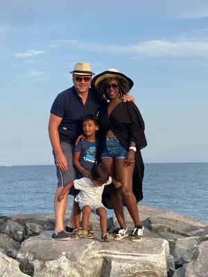 a family posing on the rocks at the beach at RS10 B&B Turnhout in Turnhout