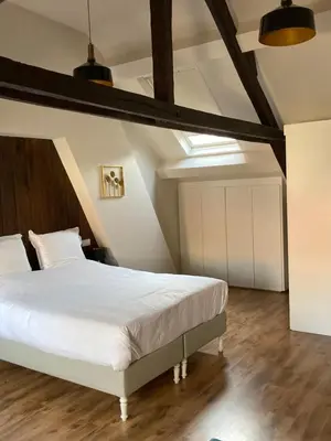 a bedroom with a large white bed and wooden floors at RS10 B&B Turnhout in Turnhout
