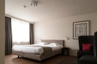 a bedroom with a large bed and a window at Hotel Karmel in Herentals