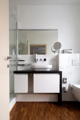 a white bathroom with a sink and a toilet at Hotel Karmel in Herentals