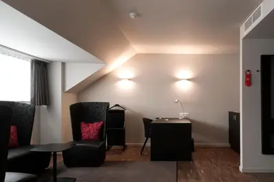 a living room with two chairs and a table at Hotel Karmel in Herentals