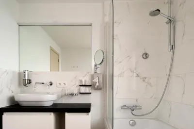 a bathroom with a sink and a shower at Hotel Karmel in Herentals