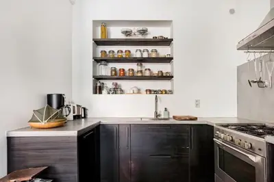 a kitchen with black cabinets and a stove at PAKHUIS in Ghent