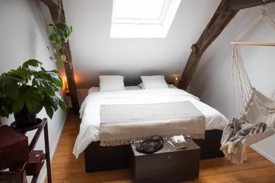 a bedroom with a hammock bed and a window at PAKHUIS in Ghent
