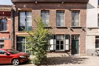 a red car parked in front of a brick building at PAKHUIS in Ghent