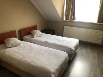 two beds in a hotel room with a window at Prestige Flats Coteaux in Brussels