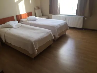 two beds in a room with wooden floors at Prestige Flats Coteaux in Brussels