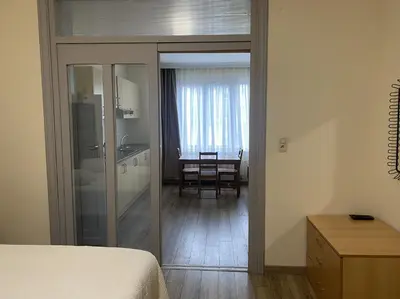 a room with a bed and a kitchen with a table at Prestige Flats Coteaux in Brussels