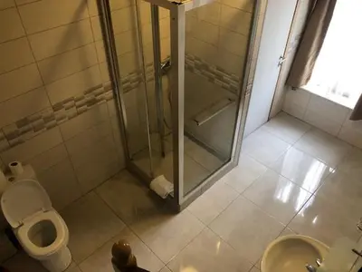 a bathroom with a shower and a toilet and a sink at Prestige Flats Coteaux in Brussels