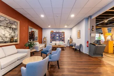 a waiting room with couches and tables and chairs at Antwerp Harbour Hotel in Antwerp