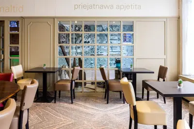 a restaurant with tables and chairs and a large window at Antwerp Harbour Hotel in Antwerp