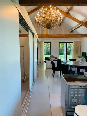 a dining room and living room with a chandelier at Landlord bij Leuven in Holsbeek