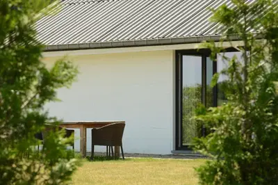 a table and chair in front of a white house at Landlord bij Leuven in Holsbeek