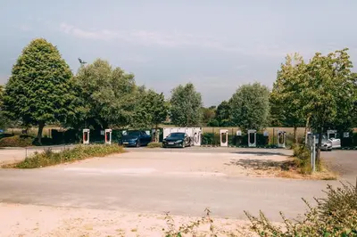 an empty parking lot with parked cars and trees at Hotel Ter Elst in Edegem