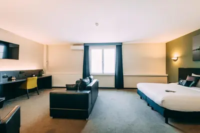 a hotel room with a bed and a desk at Hotel Ter Elst in Edegem