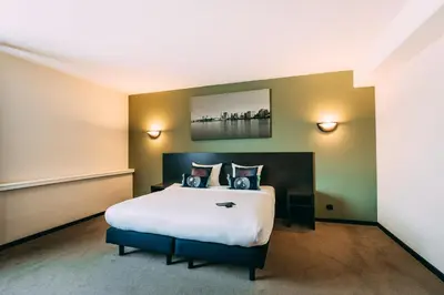 a hotel room with a large bed in it at Hotel Ter Elst in Edegem