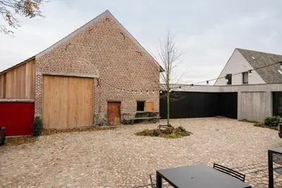an external view of a brick building with a garage at B&B Amelhof in Meise